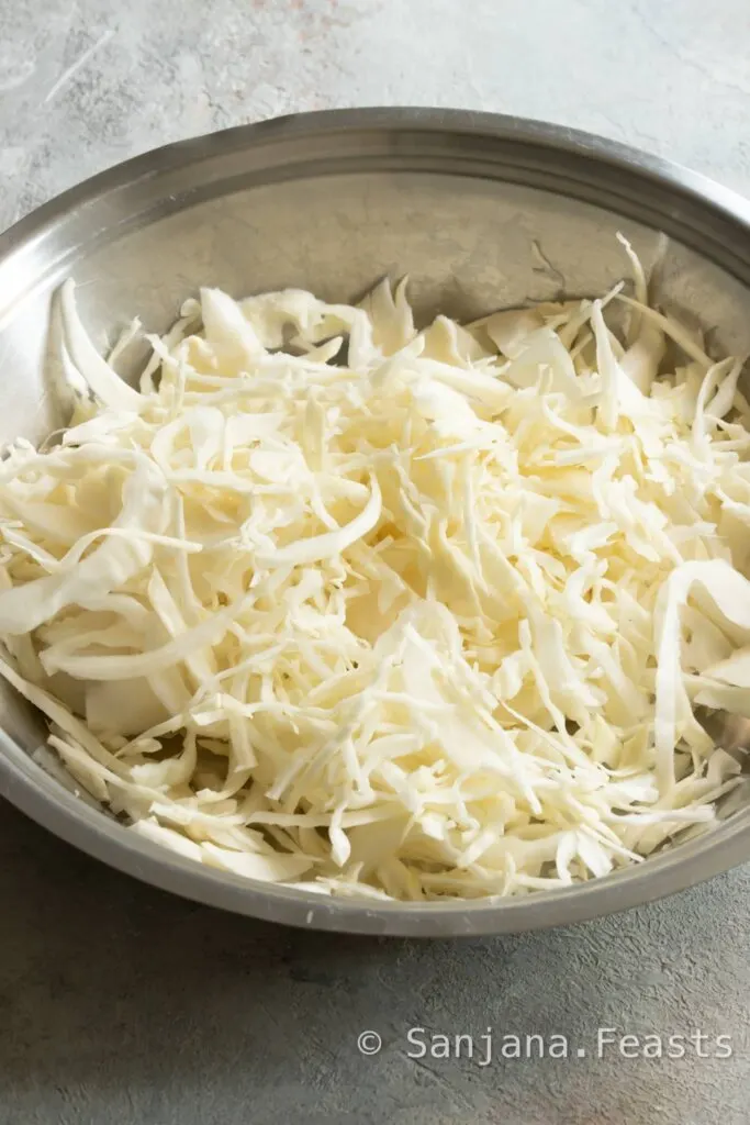 Shred white cabbage on a mandoline for even strips