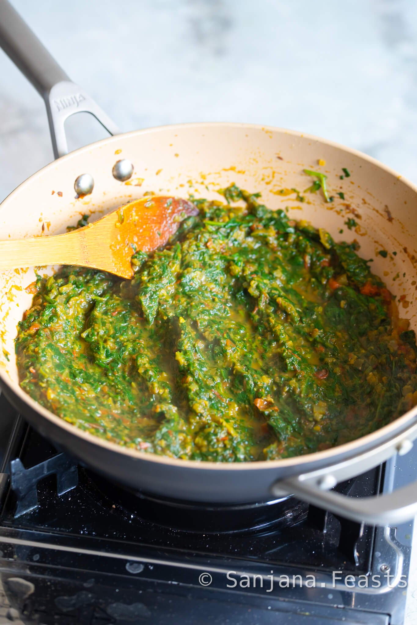 Blend the spinach for a smoother Saag Aloo