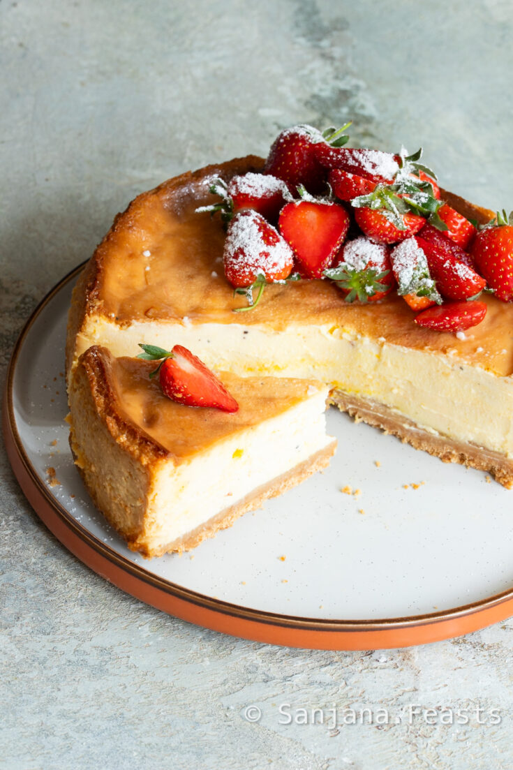 Shrikhand Cheesecake with slice and strawberries on plate