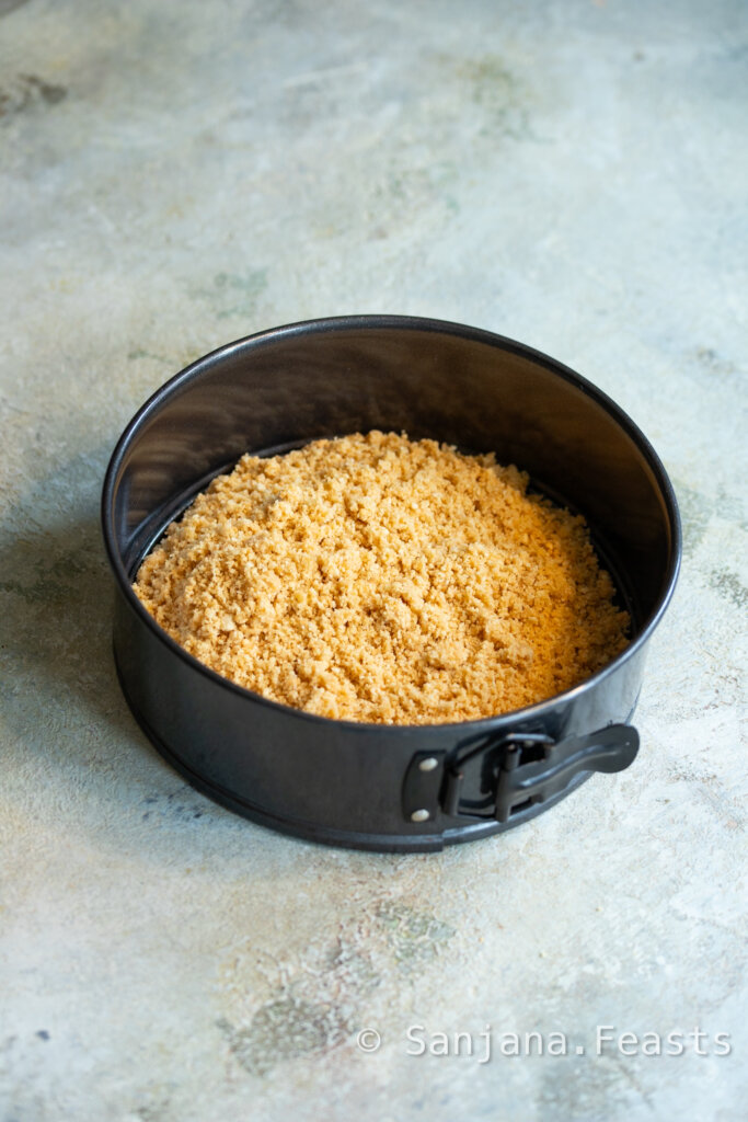 biscuit crumbs in black springform tin