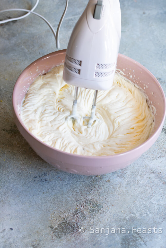 whipped cheesecake filling in bowl with electric beater