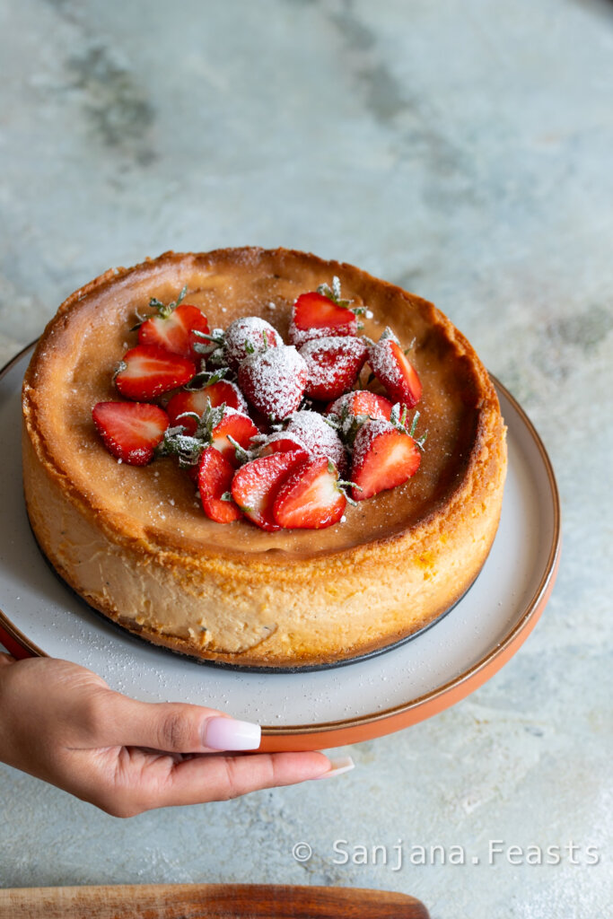 whole shrikhand cheesecake with strawberries on a plate